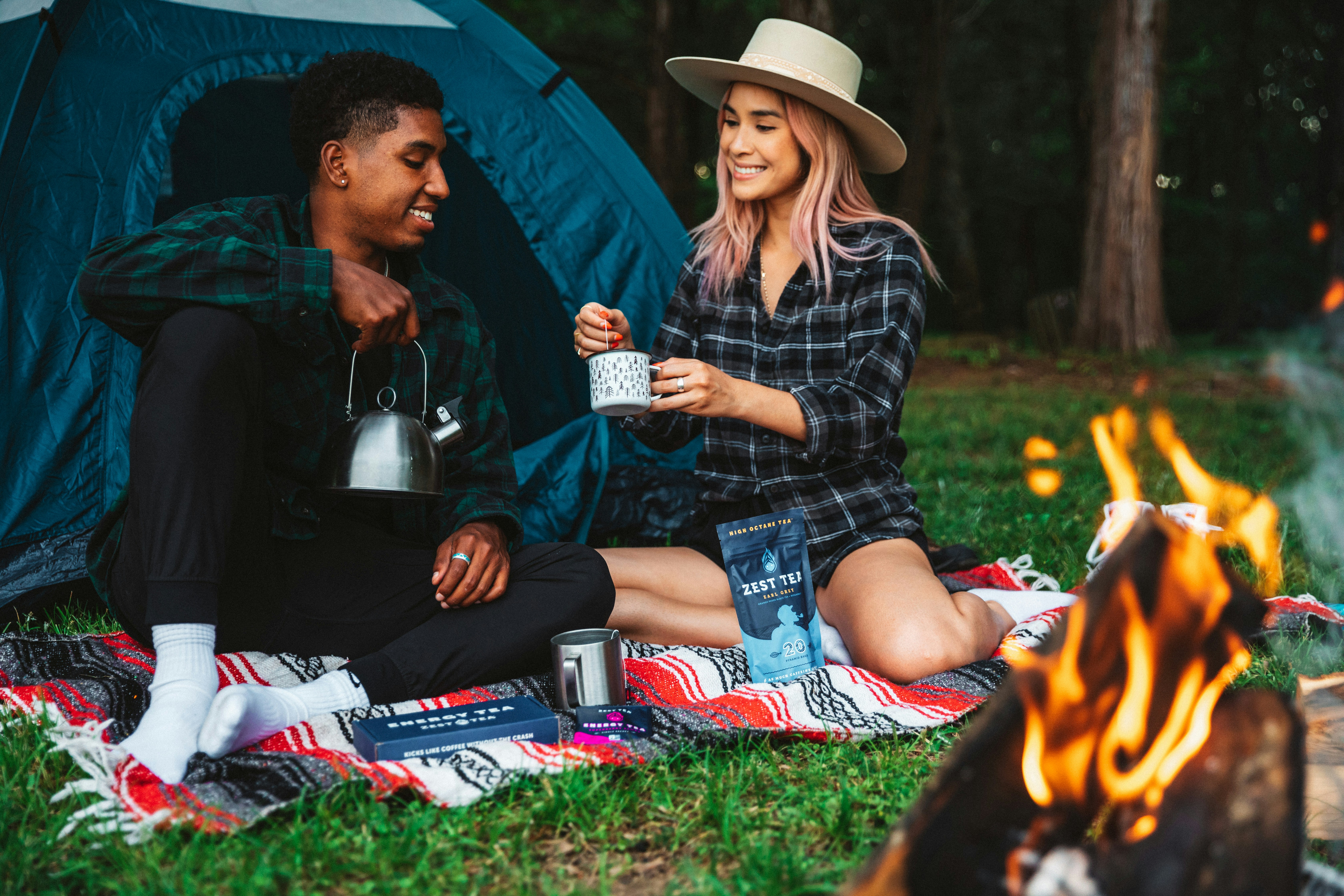 A couple sitting by a campfire at dusk - solo camping for two relationship bonding