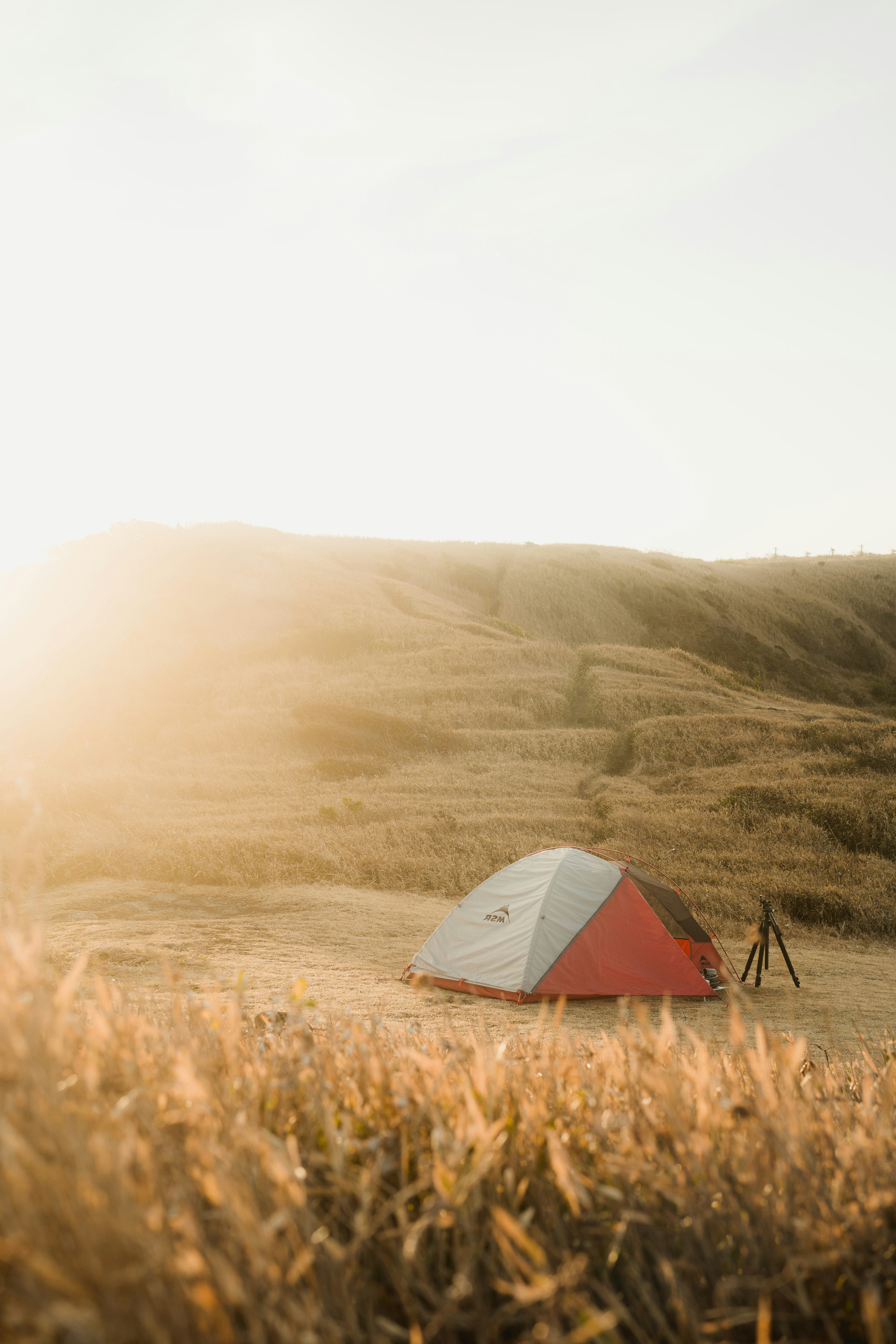 A solo camper taking a photo of a mountain lake - solo camping photography tips