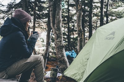 Woman solo camper enjoying nature - solo camping safety tips for women